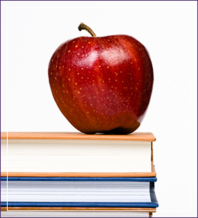 a red apple on a stack of books